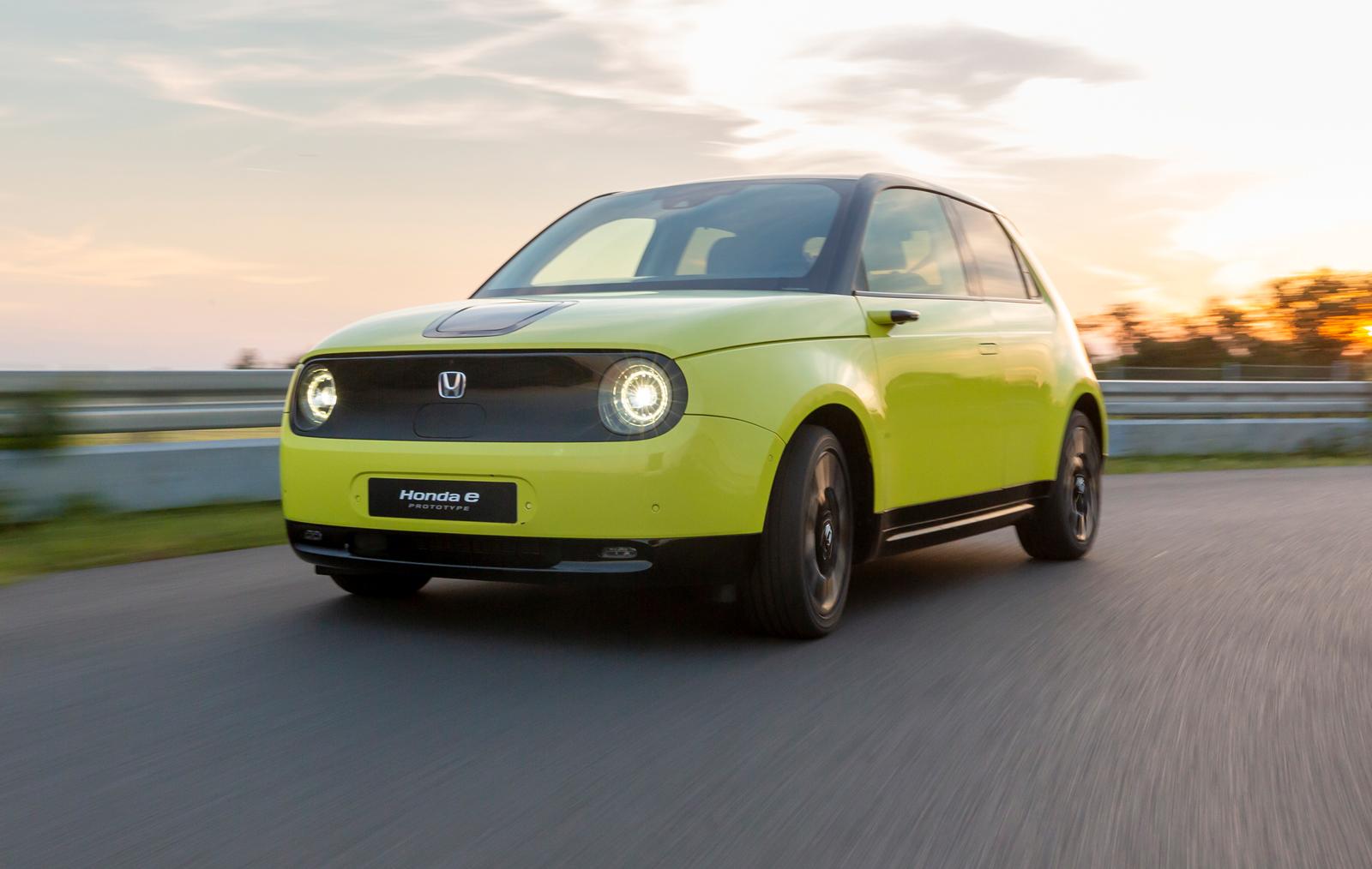 A lime-green Honda E small electric car driving around a track