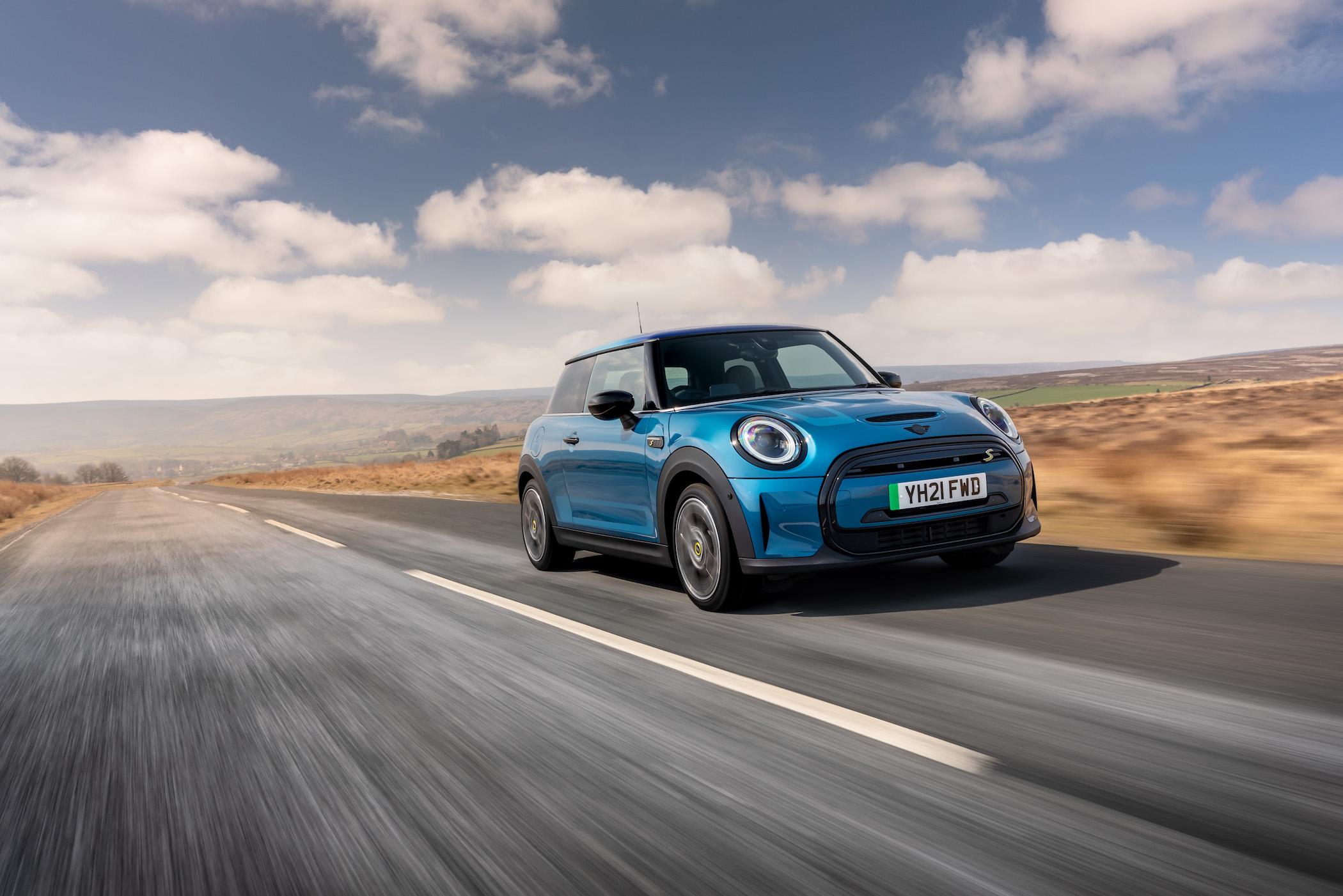 A Mini Hatchback small electric car driving down a highway 