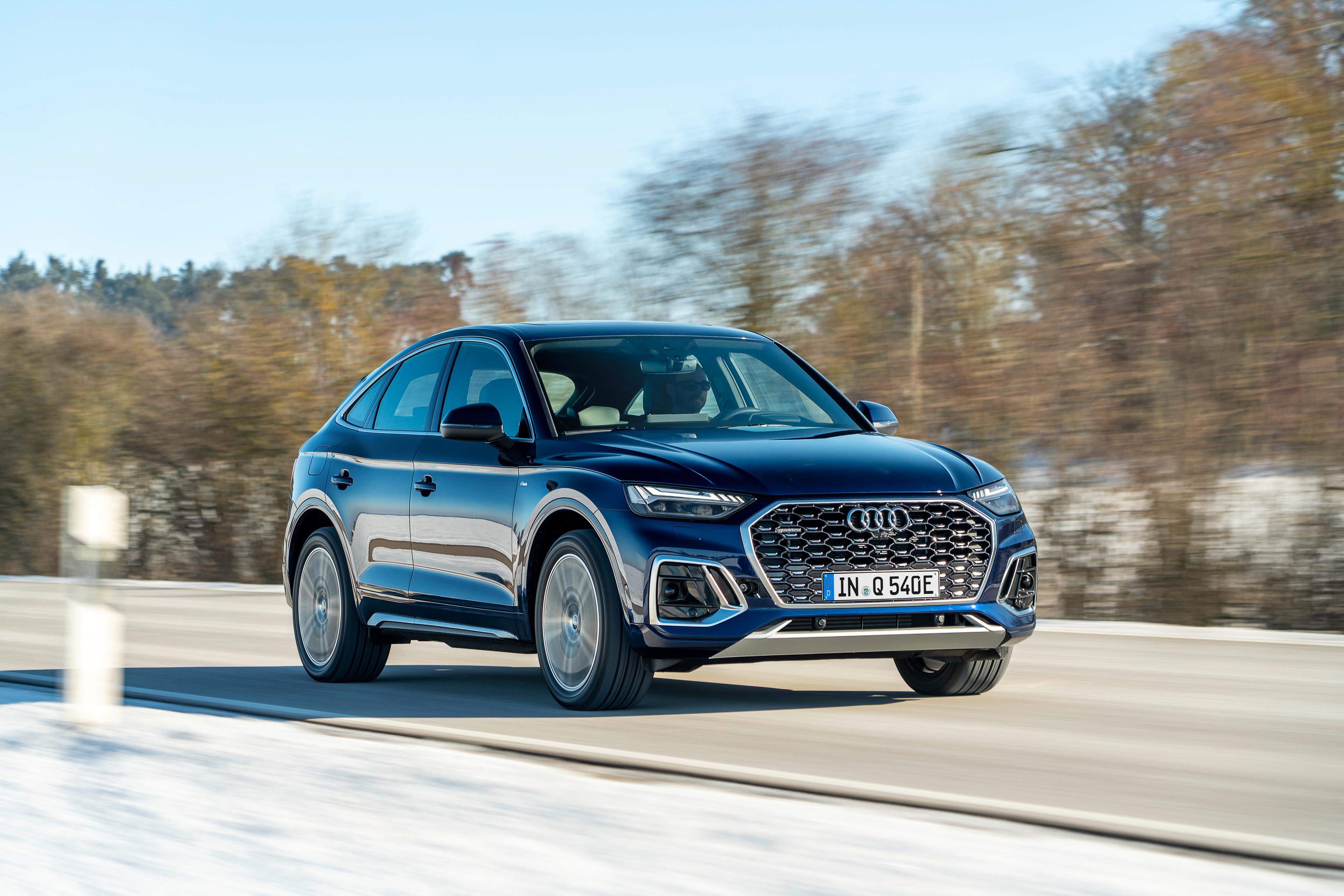 a dark blue Audi Q5 PHEV driving on a snowy road